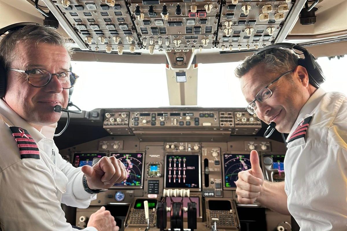 Dans le cockpit d’un Boeing 747 en croisière, deux pilotes se retournent vers l’objectif