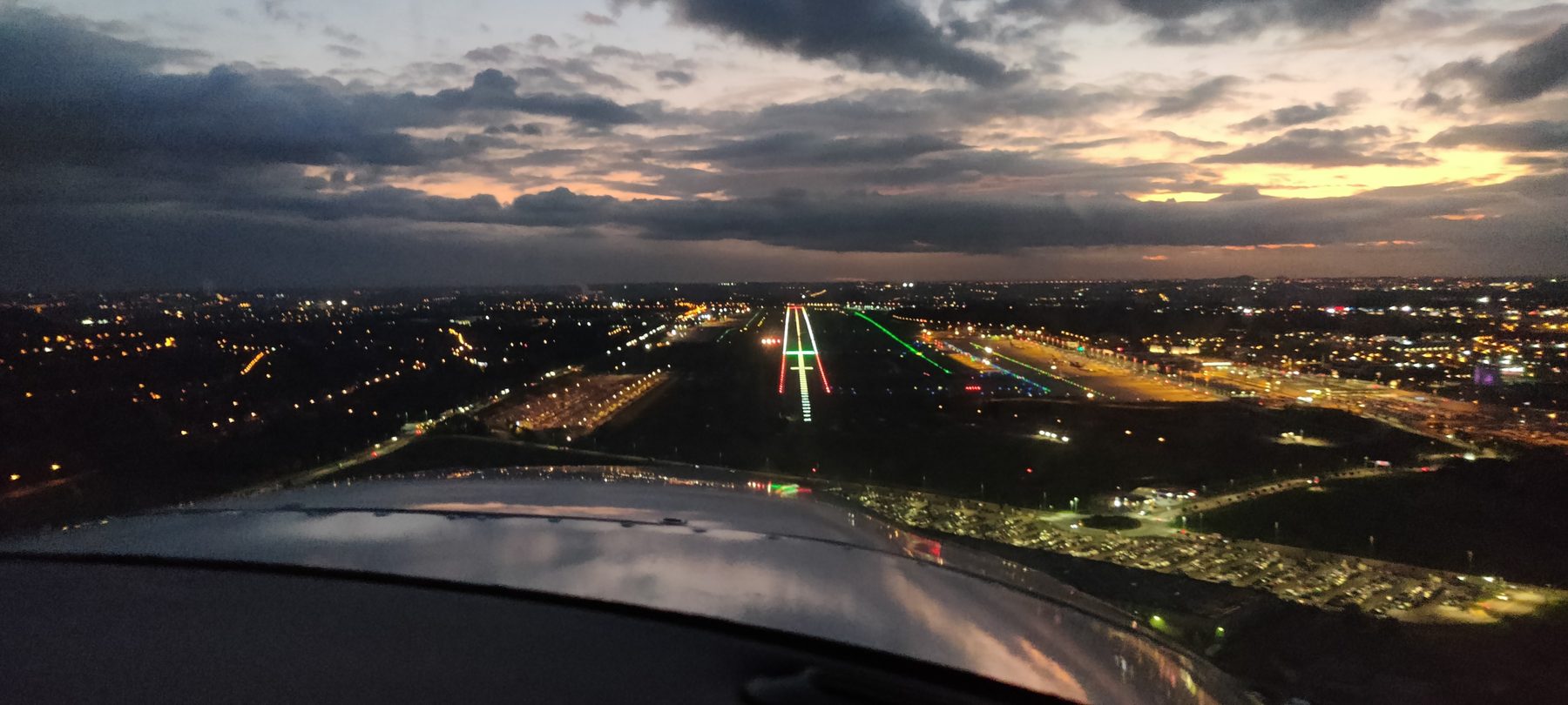 Approche de nuit : la piste illuminée vue du cockpit